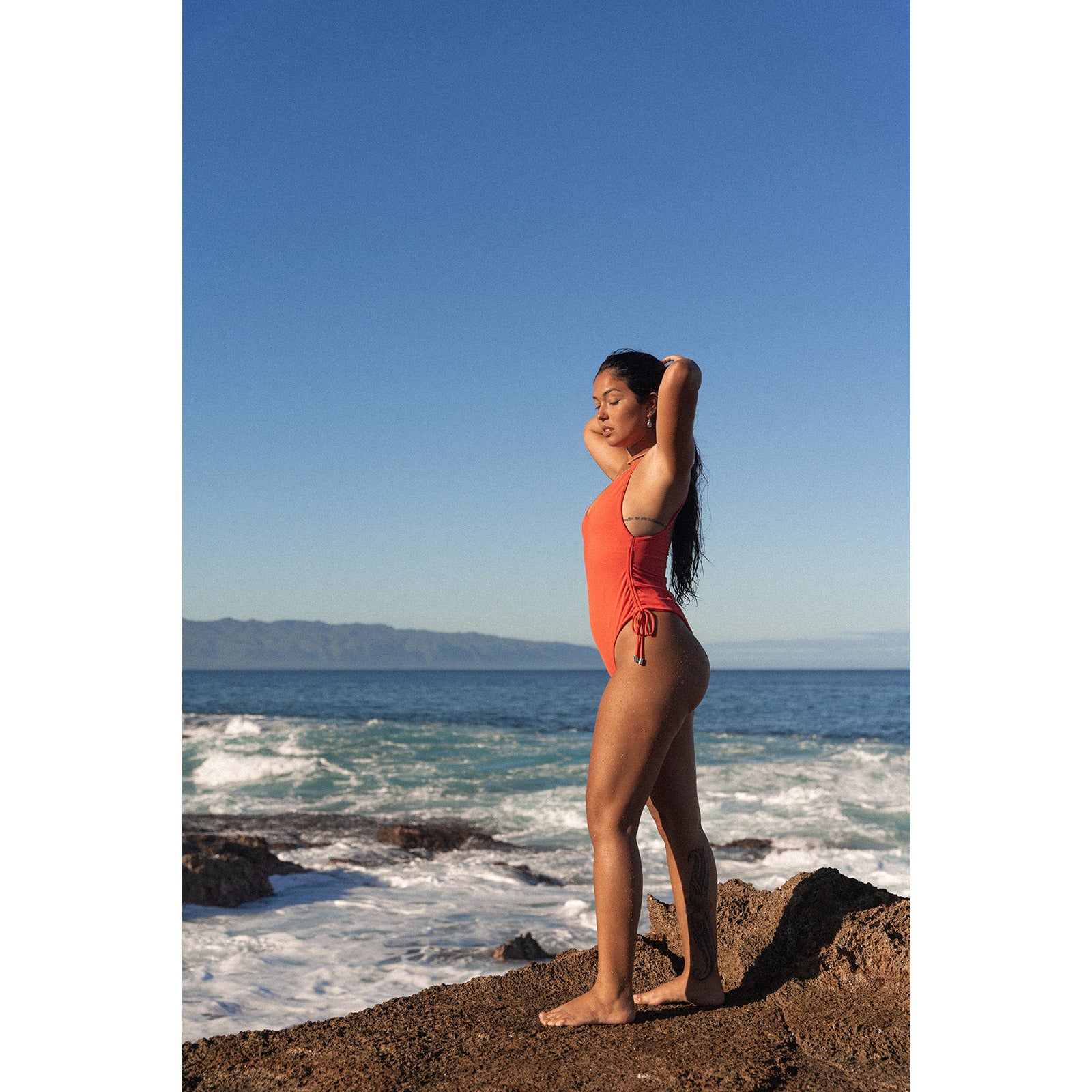 Cheeky one piece swimsuit in vibrant sunlight – trendsetting one piece swimwear for a modern, confident look.